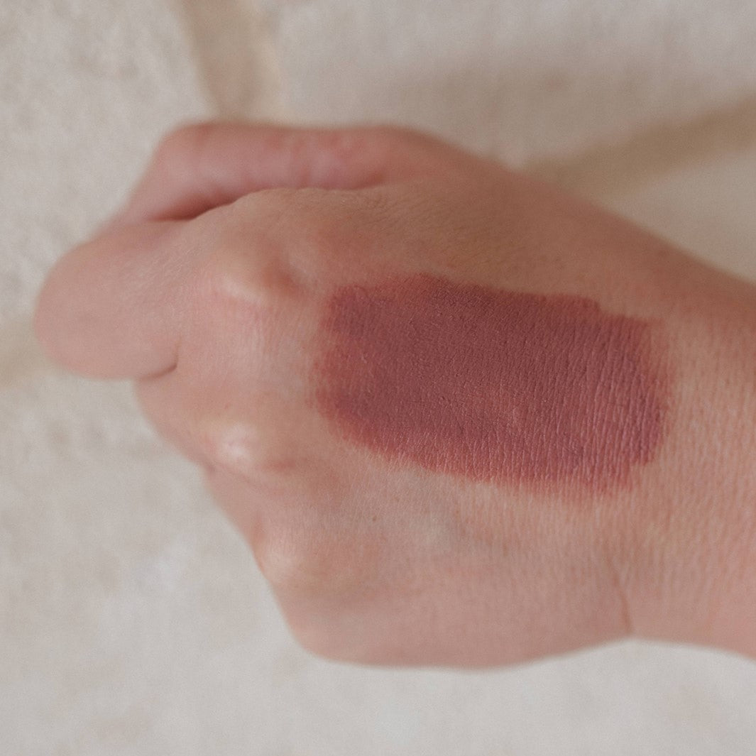 Lip and Cheek Balm in shade Rose smudged on a hand